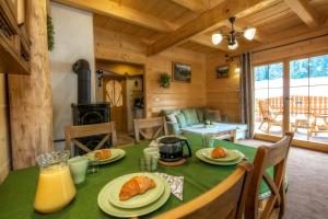 a dining room with a table and a fireplace in a log cabin at Domek Otulina in Zakopane