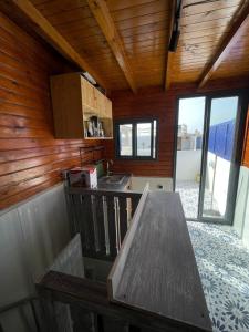a kitchen with a wooden ceiling and a wooden table at Surf house in Essaouira