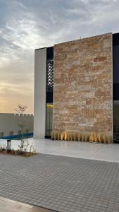 a large building with a brick wall and a building at اصيلة فيلا Asilah Villa in Buraydah