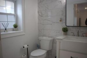 a white bathroom with a toilet and a sink and a tub at Ekimo Elite Leisure in Jersey City +19 photos