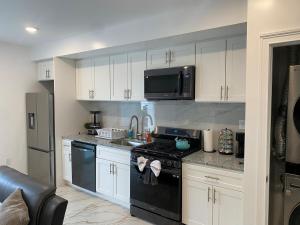 a kitchen with a black stove and a microwave at Ekimo Elite Leisure in Jersey City