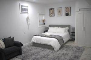 a white bedroom with a bed and a couch at Ekimo Elite Leisure in Jersey City