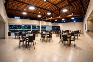 a restaurant with tables and chairs in a room at Apto Porto de Galinhas in Porto De Galinhas