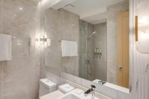 a bathroom with a sink and a shower and a toilet at City Garden Hotel Makati in Manila