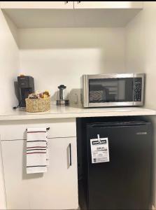 a kitchen with a black refrigerator and a microwave at Quiet Private Room Victoria - PS5, Fast WiFi, Parking in Langford