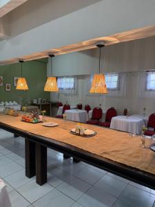a large table in a room with red chairs at Hotel Morada de Leste Pontal in Pontal do Paraná