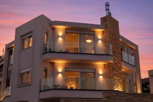 a white building with a sunset in the background at Elia Luxury Residence in Chalkida