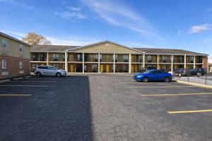 a large building with two cars parked in a parking lot at Days Inn by Wyndham Amherst OH - Near Cleveland Cedar Point & Lake Erie in Amherst