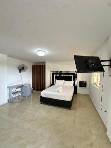 a bedroom with a bed and a flat screen tv at San Alejo in Tuluá