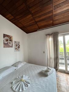 a bedroom with a large bed with a window at Hotel Morada de Leste Pontal in Pontal do Paraná