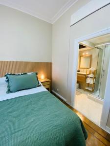 a bedroom with a bed with a green blanket at Iconic Obelisco Studio in Buenos Aires