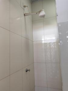 a shower with a glass door and a light at Aluguel de um quarto - Espaço Maranata in Porangatu +2 photos