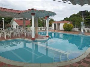 a pool at a resort with a table and chairs at Alborada Chinauta in La Serena