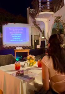 a woman sitting at a table in front of a screen at Hotel Sol de Ica in Ica