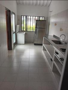 a white kitchen with a sink and a refrigerator at Alborada Chinauta in La Serena