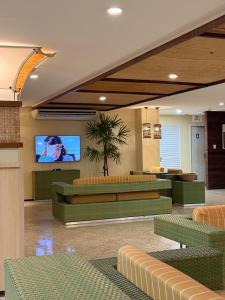 a lobby with couches and a flat screen tv at Gran Lençóis Flat Residence Mandacaru 411 in Barreirinhas