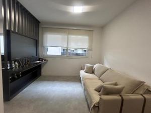 a living room with a couch and a flat screen tv at Loft Exclusivo - Maxplaza in Canoas