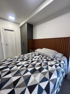 a bedroom with a black and white checkered bed at Loft Exclusivo - Maxplaza in Canoas +19 photos