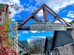 a sign in front of a building with a mountain at Renovated Chalet at Mystic Springs, Pool, Hot Tub! in Canmore