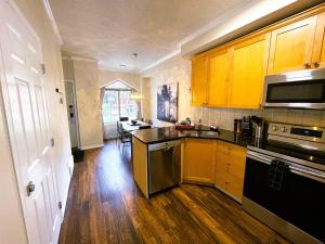 a kitchen with wooden cabinets and a stove top oven at Renovated Chalet at Mystic Springs, Pool, Hot Tub! in Canmore +31 photos