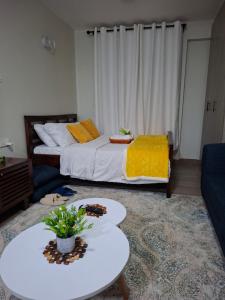 a bedroom with a bed and a table and a couch at BlueByMis in Muchatha