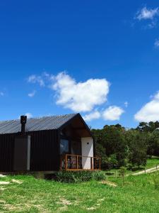 a black and white house on a grass field at Hospedagem na natureza in Garopaba