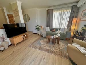 a living room with a couch and a tv at Ocean Breeze in Perth