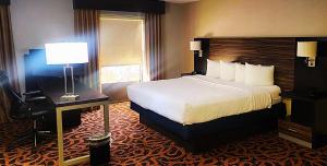 a hotel room with a bed and a desk with a lamp at Baymont by Wyndham Midland TX in Midland