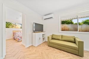 a living room with a couch and a tv at Modern Family Home Near Fiona Stanley & Murdoch Uni in Perth