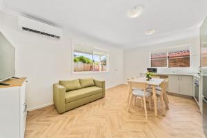 a living room with a table and a couch at Modern Family Home Near Fiona Stanley & Murdoch Uni in Perth