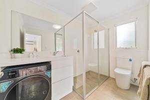 a bathroom with a washer and dryer in it at Modern Family Home Near Fiona Stanley & Murdoch Uni in Perth +20 photos