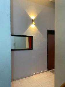 a mirror on a wall with a light on it at Best Homestay in Kuala Rompin