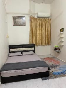 a bedroom with a bed and a window at Best Homestay in Kuala Rompin