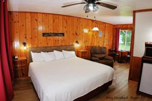 a bedroom with a white bed and a chair at Park Motel and Cabins in Florence