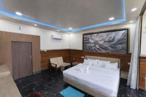 a bedroom with a white bed and a chair in it at Ankush Resort in Vishnupur +14 photos