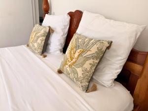 two pillows sitting on top of a bed at Sweet Nest Villa in Sainte-Rose