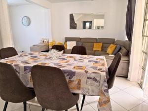 a dining room table with chairs and a couch at Sweet Nest Villa in Sainte-Rose +13 photos