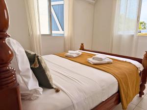 a bedroom with a bed with two towels on it at Sweet Nest Villa in Sainte-Rose