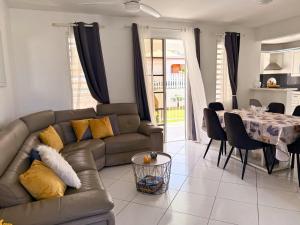 a living room with a couch and a table at Sweet Nest Villa in Sainte-Rose
