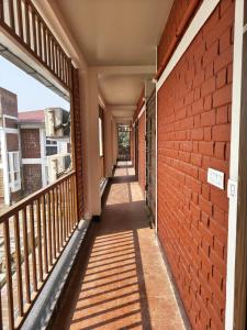a corridor of a building with a brick wall at Ankush Resort in Vishnupur