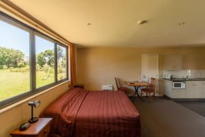 a bedroom with a bed and a large window at Waterfront motel in Blenheim