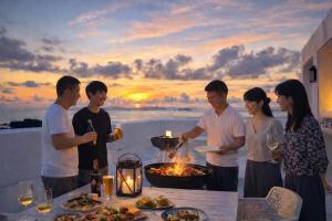 a group of people standing around a table with a grill at 天海の城 in Saikai