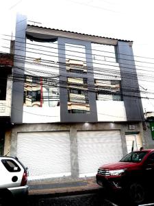 a building with two garages with cars parked in front of it at Tourist House Suites Otavalo in Otavalo