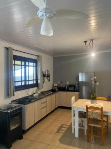 a large kitchen with a table and a dining room at Casa de Férias Balneário Gaivota in Balneário Gaivotas
