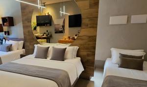 two beds in a room with a mirror on the wall at D Suítes - Checkin ate 21 Hs - ZAP pras coordenadas de acesso - Dois ENDEREÇOS in Goiânia