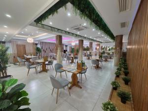 a restaurant with tables and chairs and plants at Hostal Carlos I in Herrera del Duque