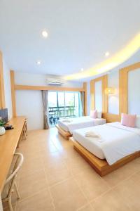 a hotel room with two beds and a desk and a desk at Wangpruksa Resort in Ban Nong Bua +60 photos