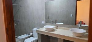 ein Badezimmer mit zwei Waschbecken, einer Toilette und einem Spiegel in der Unterkunft Mi Valle in Cafayate