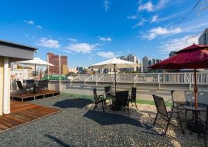 a patio with tables and chairs and umbrellas on a roof at OstelloMaree 오스텔로마레 Tax Benefit in Seoul