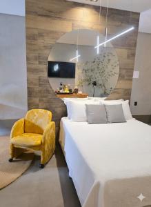 a bedroom with a bed and a yellow chair at D Suítes - Checkin ate 21 Hs - ZAP pras coordenadas de acesso - Dois ENDEREÇOS in Goiânia